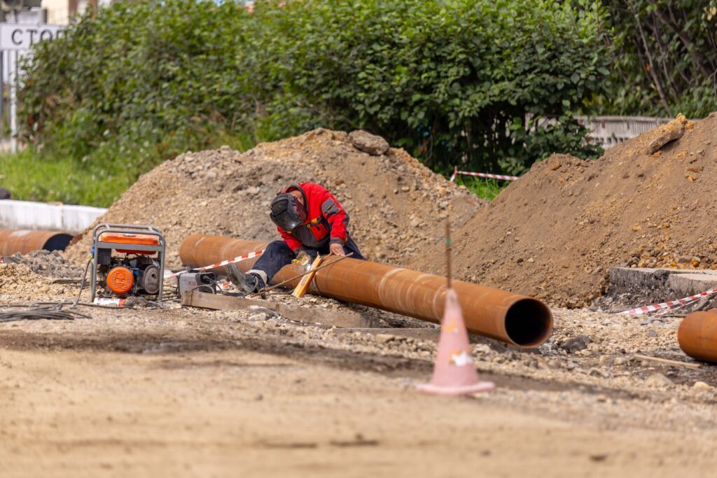 A construction worker cutting a pipe